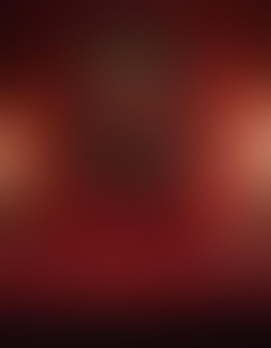 A luxurious, softly-lit boudoir with plush cushions and a tasteful collection of sensual art on the walls. A vintage video camera and a laptop displaying enticing thumbnails of erotic videos. Lush red and gold colors create an intimate atmosphere, with romantic candles casting flickering shadows. Subtle hints of silk and lace are showcased throughout the scene. vibrant colors. super-realistic.